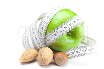 apple, nuts and measure tape isolated on white