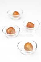 Nuts in miniature glass bowls isolated on white