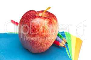 apple, colored paper and pencils isolated on white