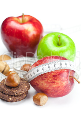 apple, nuts, cookies and measure  tape isolated on white