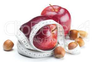 apple, nuts and measure tape isolated on white