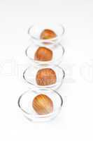 Nuts in miniature glass bowls isolated on white