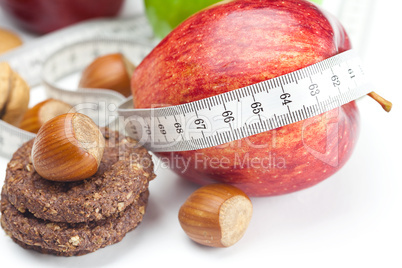 apple, nuts, cookies and measure  tape isolated on white