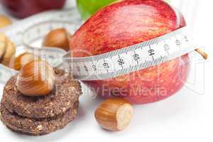 apple, nuts, cookies and measure  tape isolated on white