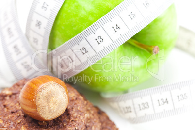 apple, nuts, cookies and measure  tape isolated on white