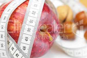 apple, nuts and measure tape isolated on white