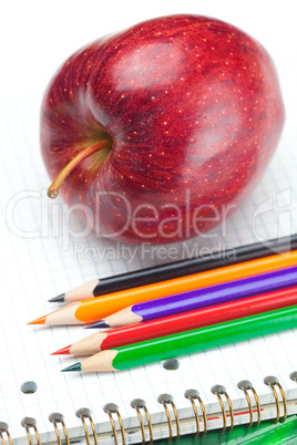 apple, notebooks and pencils isolated on white