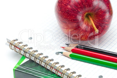 apple, notebooks and pencils isolated on white