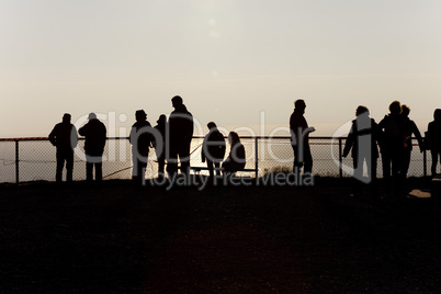 Silhouettes of people at the fence