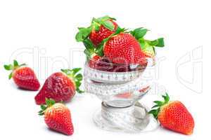 big juicy red ripe strawberries in a glass bowl and measure tape