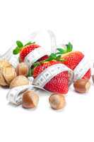 big juicy red ripe strawberries,nuts and measure tape isolated o