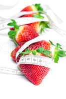 big juicy red ripe strawberries and measure tape isolated on whi