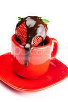 strawberries in chocolate lying in a red cup isolated on white