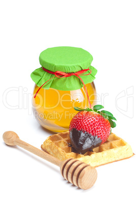 big juicy ripe strawberries in chocolate, a jar of honey and waf