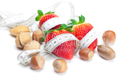 big juicy red ripe strawberries,nuts and measure tape isolated o
