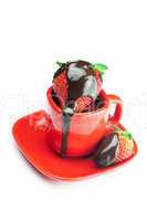 strawberries in chocolate lying in a red cup isolated on white