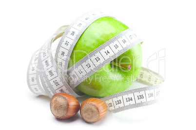 apple, nuts and measure  tape isolated on white