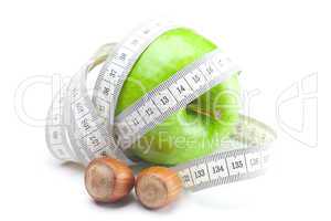 apple, nuts and measure  tape isolated on white