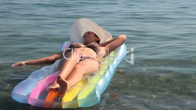 young woman is swimming on  air bed
