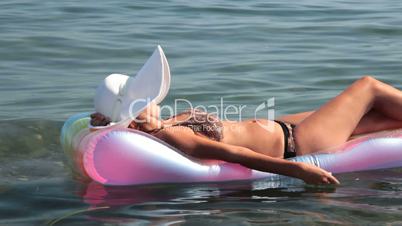 woman floating on inflatable mattress