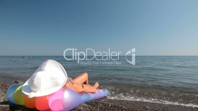 woman in white sun hat relaxing on beach