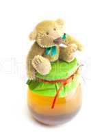 teddy bear  and  jar of honey  isolated on white