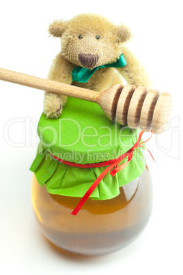 teddy bear ,stick to hohey  and  jar of honey  isolated on white