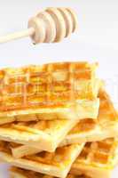 delicious Belgian waffles and stick to honey isolated on white