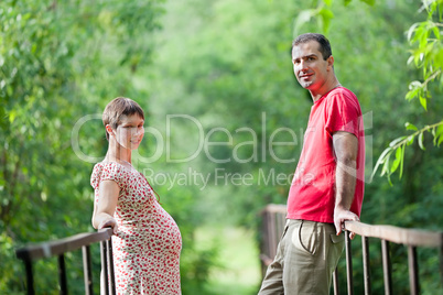 Husband with his pregnant wife on the bridge