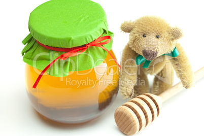 teddy bear ,stick to hohey  and  jar of honey  isolated on white