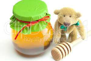 teddy bear ,stick to hohey  and  jar of honey  isolated on white