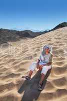 Boy sitting on sand dune in Egypt