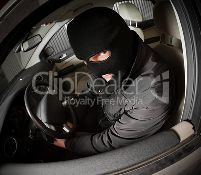 robber and the thief in a mask hijacks the car