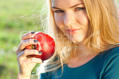 portrait of a beautiful young woman with apple  outdoor