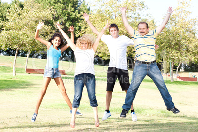 Family jumping high in the air on a green meadow
