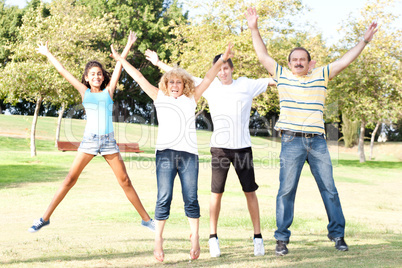 Family jumping with wide-spread raised arms