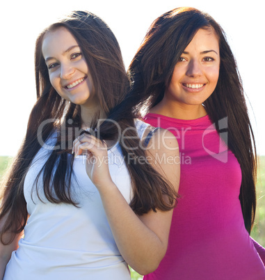 portret of two young beautiful woman on the  sky background