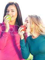 portret of two young beautiful woman with apple on the  sky back