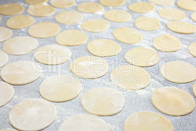 round shape of the dough with flour on the table