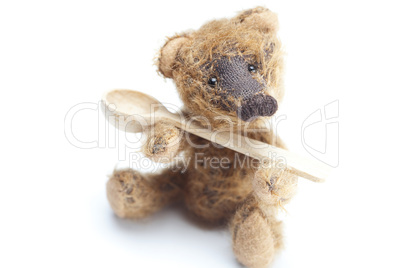 Teddy Bear and a wooden spoon isolated on white