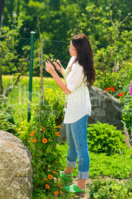 Summer gardening young beautiful woman cut flower