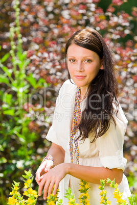 Beautiful woman sunny garden care yellow flowers