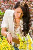 Beautiful woman sunny garden care yellow flowers