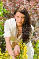 Beautiful woman sunny garden care yellow flowers