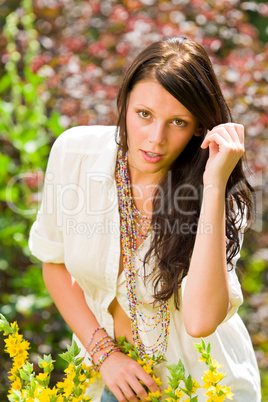 Beautiful woman sunny garden care yellow flowers