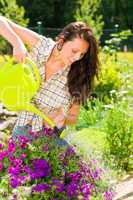 Gardening smiling woman watering can violet flower