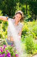 Summer garden smiling woman watering hose flower