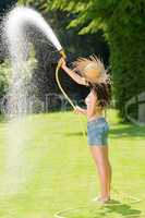 Summer garden woman play with water hose