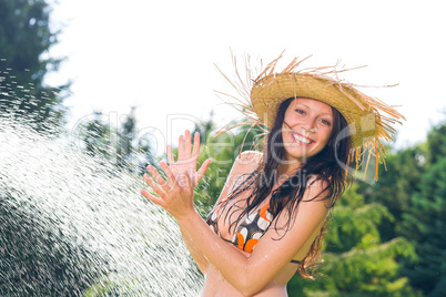 Summer garden smiling woman swimsuit splash water