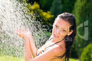 Summer garden smiling woman swimsuit splash water